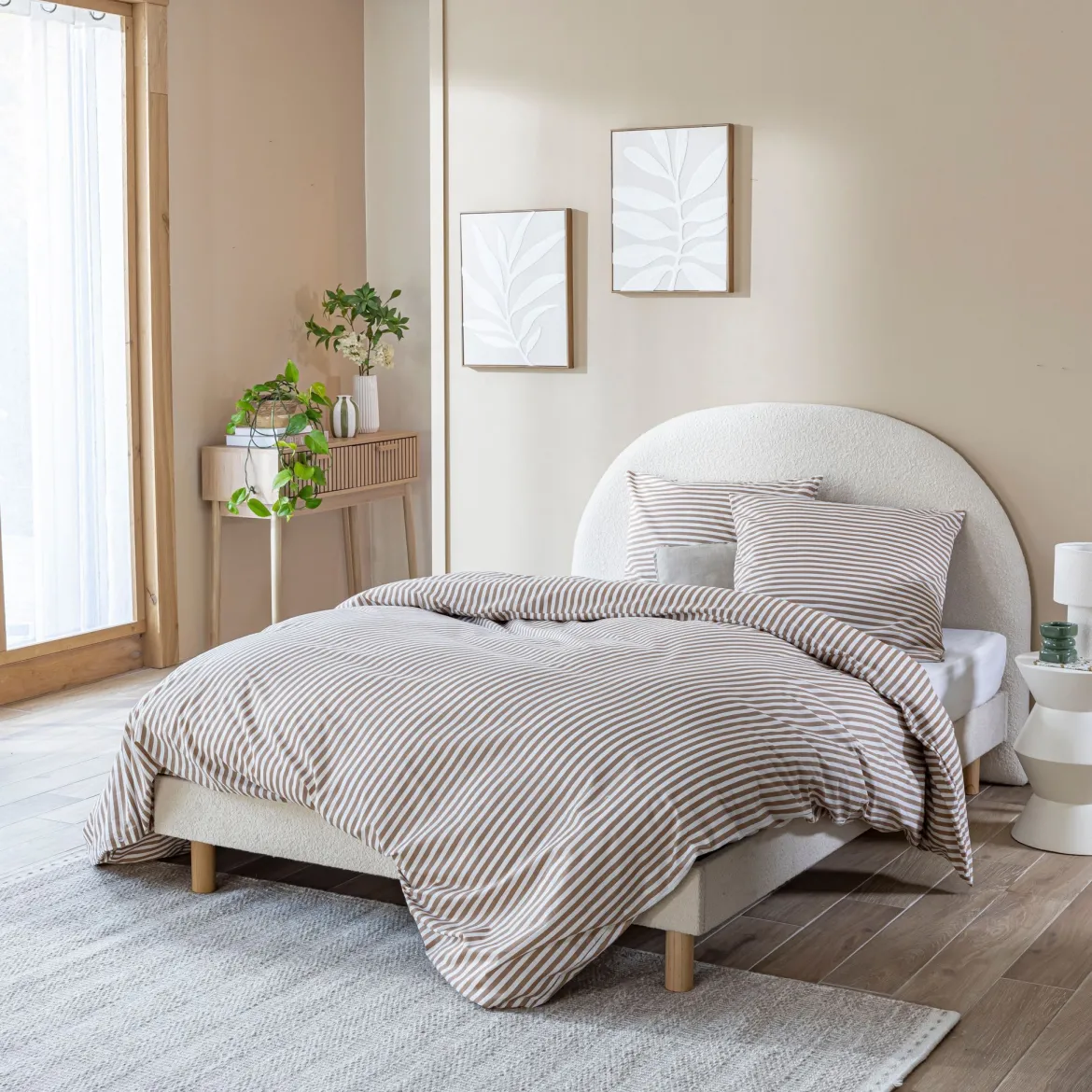 Lit tissu beige avec tête de lit bouclette